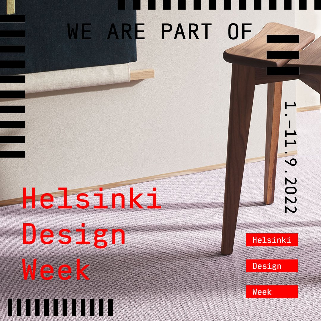 Sisustuskuva tilasta, jossa vaaleanpunainen kokolattiamatto ja oikealla yläkulmassa puoliksi näkyvä puujakkara. Kuvassa myös mustia ja punaisia graafisia elementtejä, joissa lukee Helsinki Design Week.