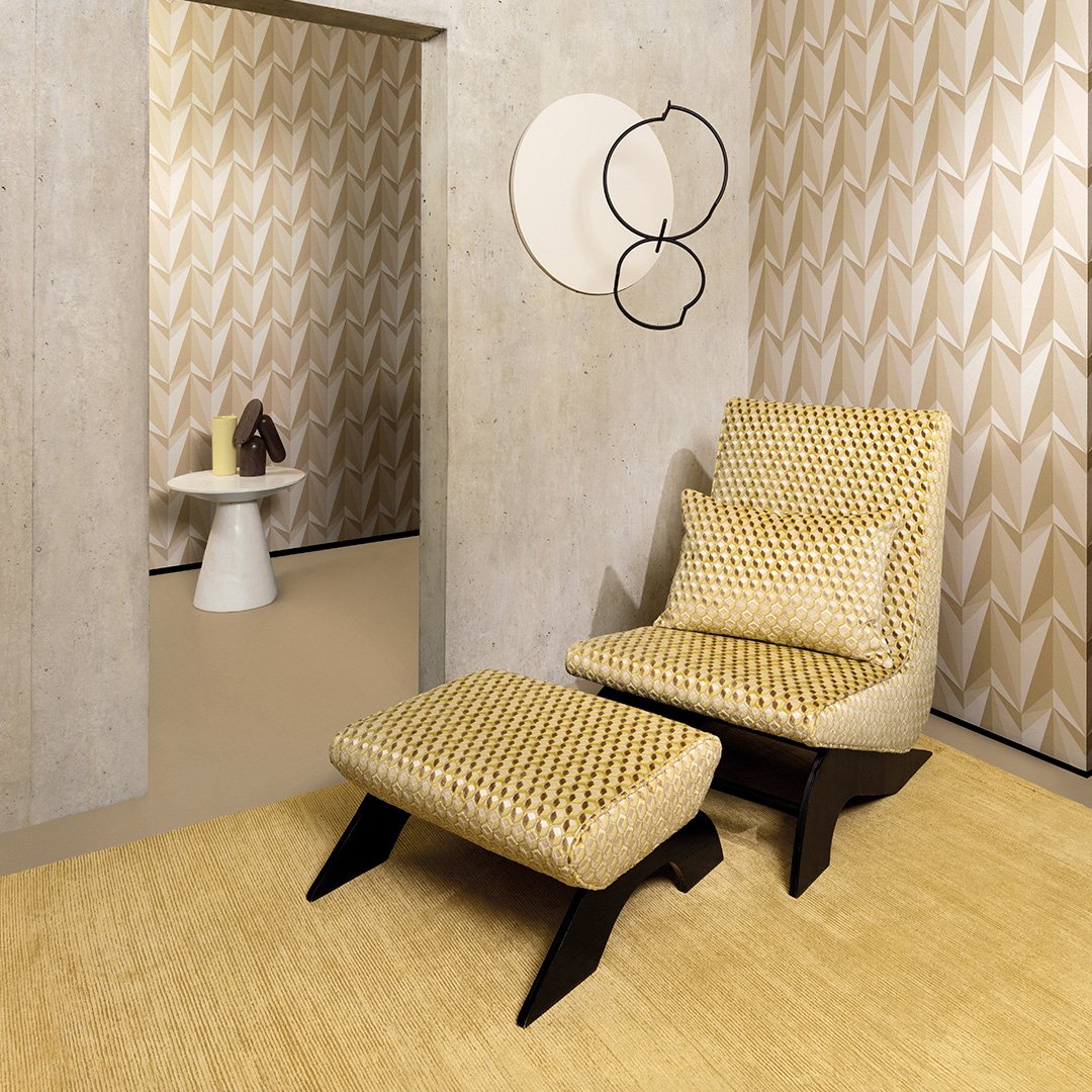 Sinapinkeltainen matto sekä nojatuoli rahilla, jotka on molemmat verhoiltu hunajakennoa muistuttavalla hohtavan keltaisella kankaalla.