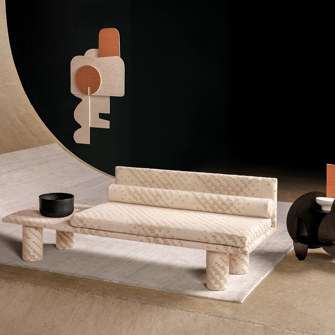 Daybed-tyylinen huonekalu verhoiltuna Kirkby Designin vaalen beigellä kohokuvioidulla verhoilukankaalla.