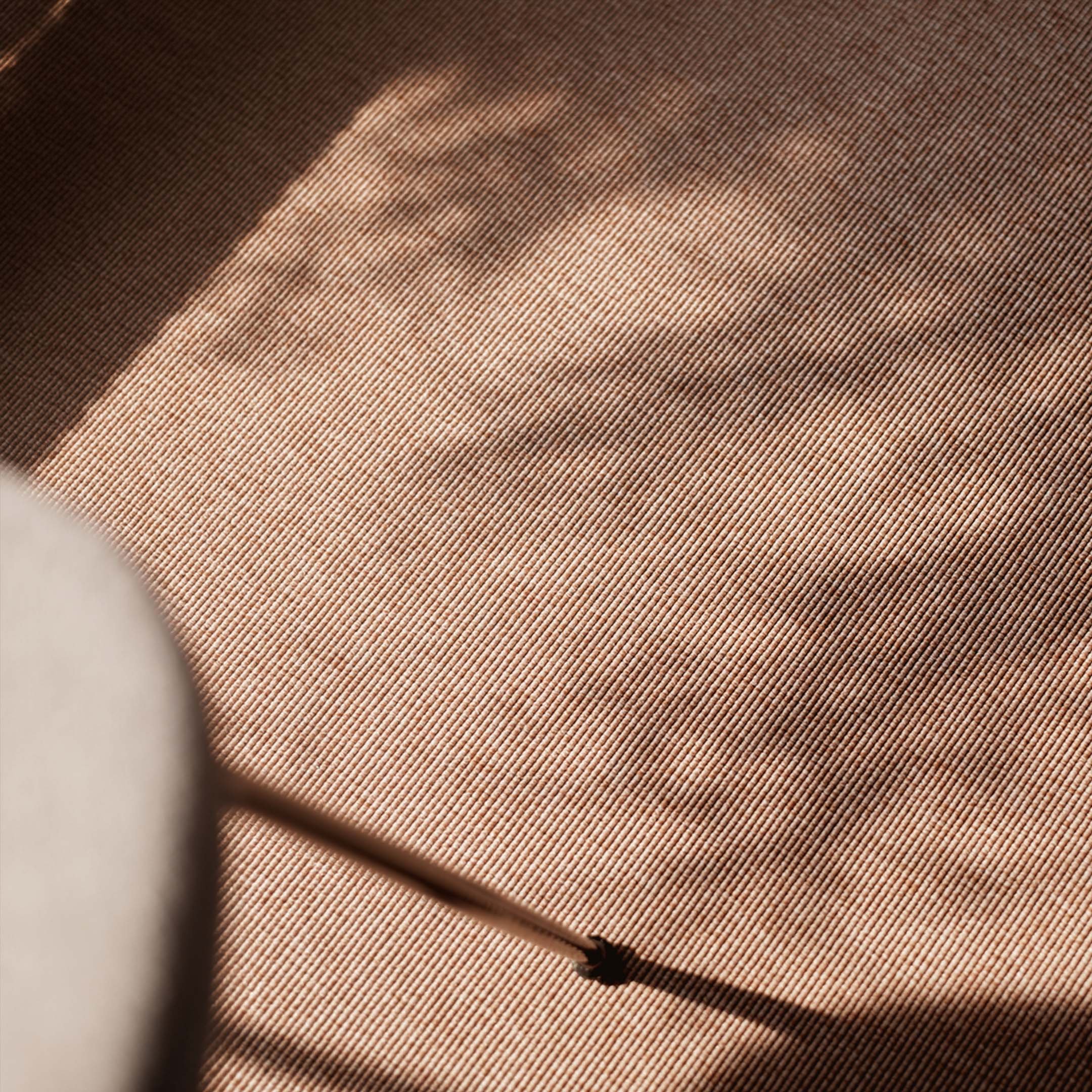 Lähikuva persikanvärisestä teksiililattiasta auringonpaisteessa.
